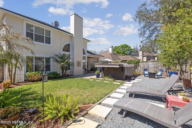 view of yard with a fenced backyard, a hot tub, and a patio