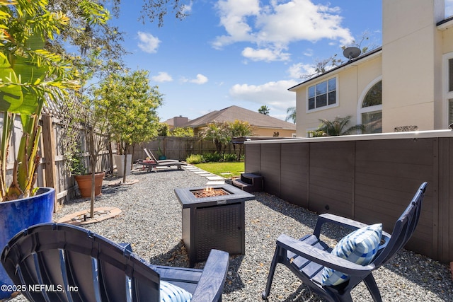 view of yard with a patio area, a fenced backyard, and an outdoor fire pit