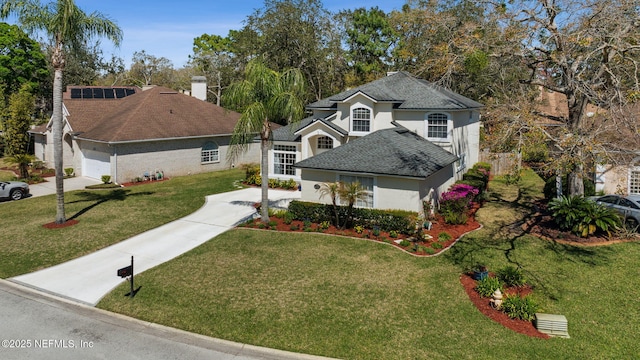 traditional-style home featuring a garage, stucco siding, concrete driveway, and a front yard