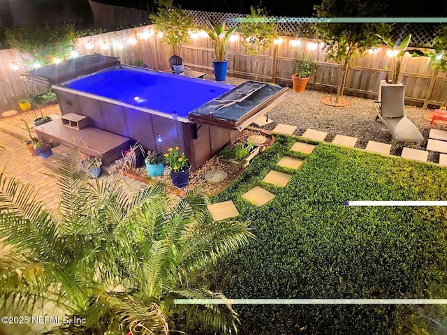 view of pool featuring a jacuzzi and a fenced backyard