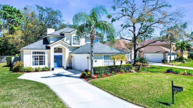 traditional home featuring a garage, a front lawn, driveway, and stucco siding