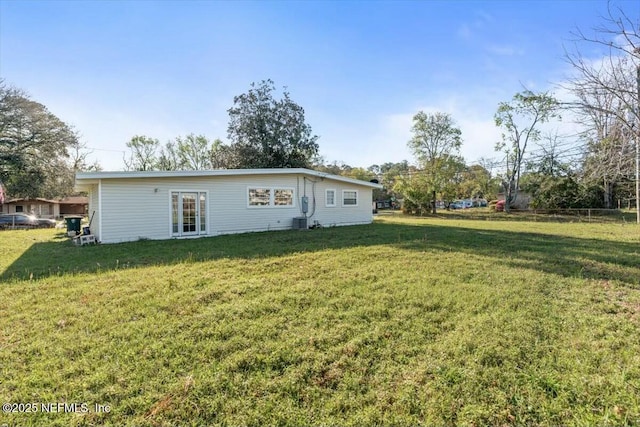 back of property featuring a lawn and cooling unit