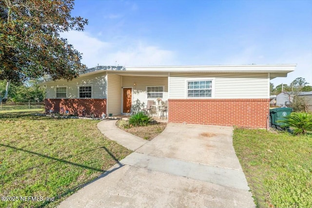 view of front facade featuring brick siding and a front yard