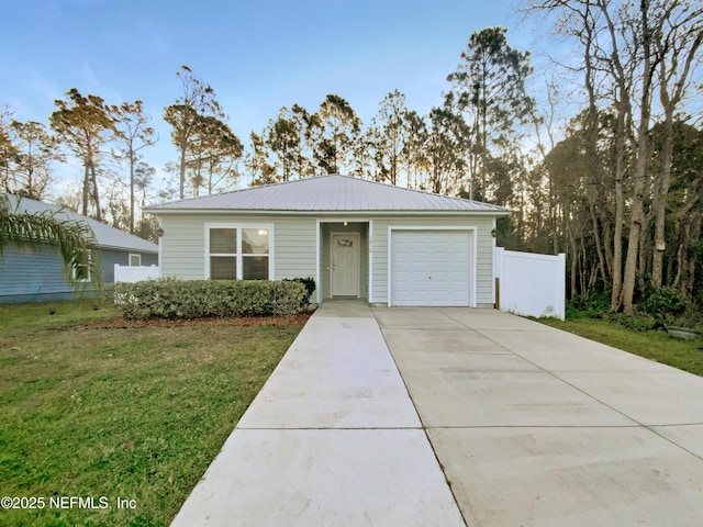 view of front of home featuring a front lawn, driveway, fence, an attached garage, and metal roof