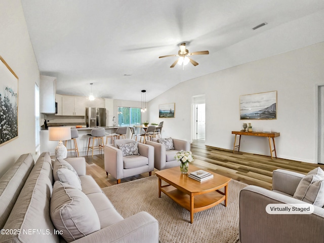 living area with ceiling fan, visible vents, lofted ceiling, and light wood-style flooring