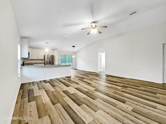 unfurnished living room featuring light wood-style flooring, baseboards, lofted ceiling, and ceiling fan