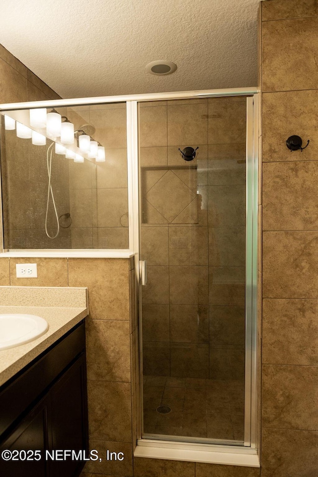 full bath featuring a stall shower and vanity