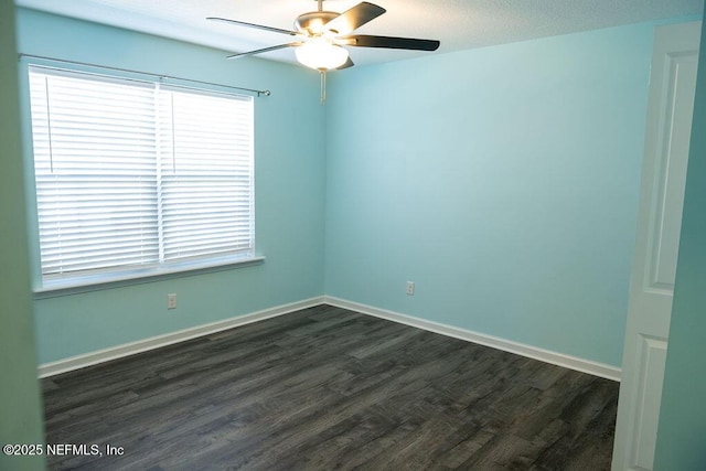 unfurnished room with baseboards, dark wood-type flooring, a healthy amount of sunlight, and a ceiling fan