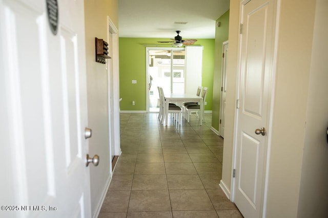 hall with tile patterned floors and baseboards