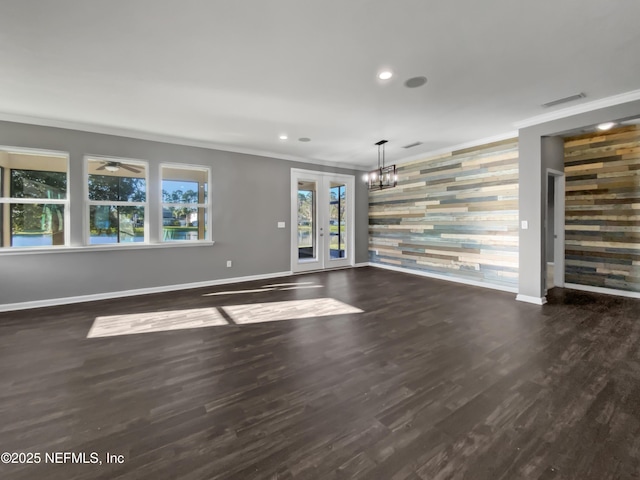 unfurnished living room featuring dark wood-type flooring, recessed lighting, crown molding, baseboards, and an accent wall