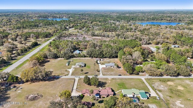 drone / aerial view with a forest view and a water view