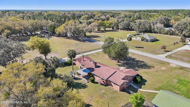 drone / aerial view featuring a rural view and a view of trees