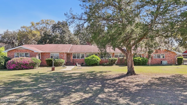 view of front facade featuring brick siding and a front yard