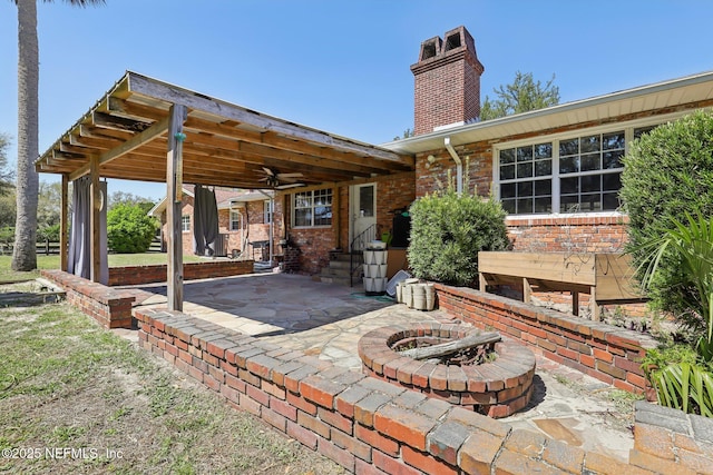 view of patio featuring entry steps, a fire pit, and a ceiling fan