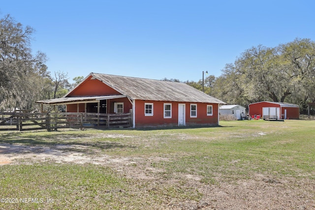 view of side of home featuring an exterior structure, metal roof, and an outbuilding