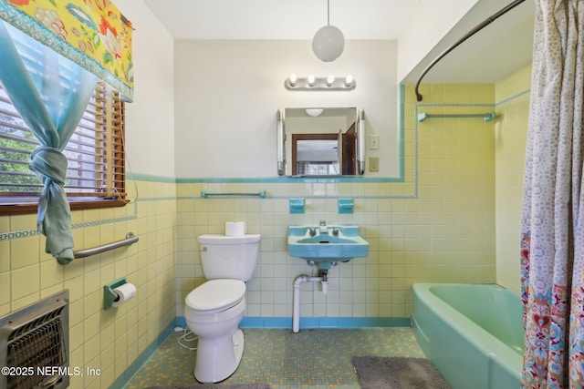 bathroom featuring toilet, shower / bath combo, heating unit, wainscoting, and tile patterned flooring