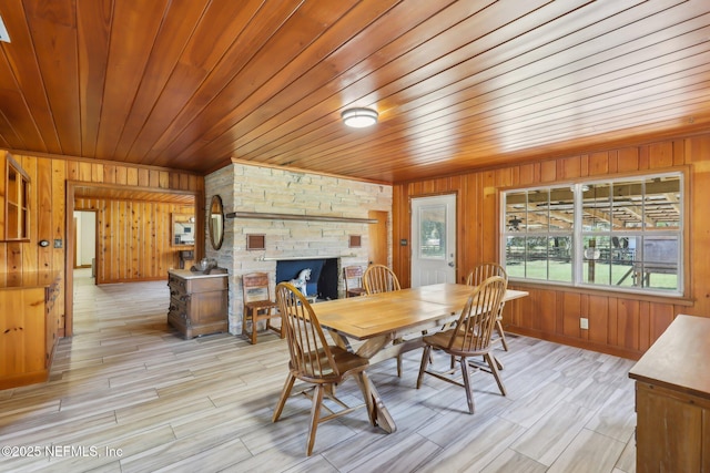 dining space with a wood stove, wooden walls, and wood ceiling