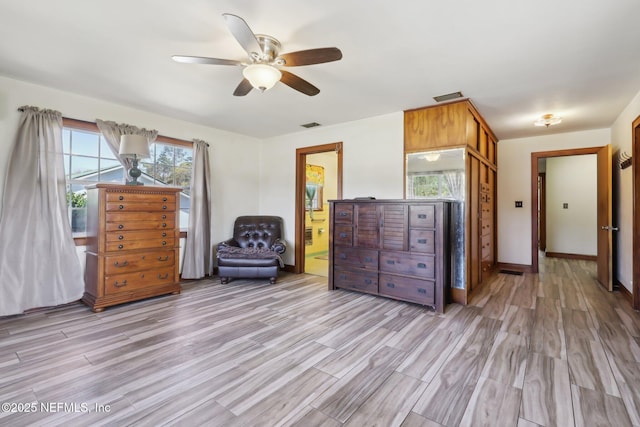 interior space with visible vents, baseboards, light wood-style floors, and a ceiling fan