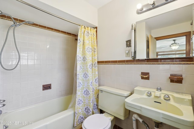 full bath featuring ceiling fan, toilet, shower / bath combination with curtain, tile walls, and a sink