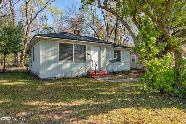 bungalow-style house with entry steps, fence, a front yard, crawl space, and a chimney