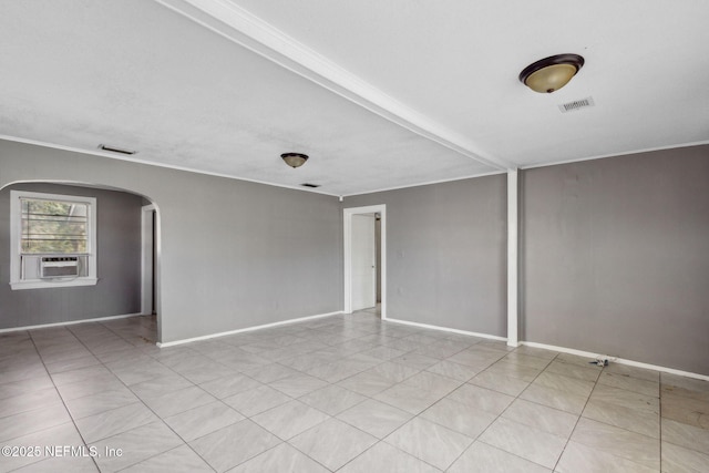 spare room with arched walkways, visible vents, baseboards, and ornamental molding