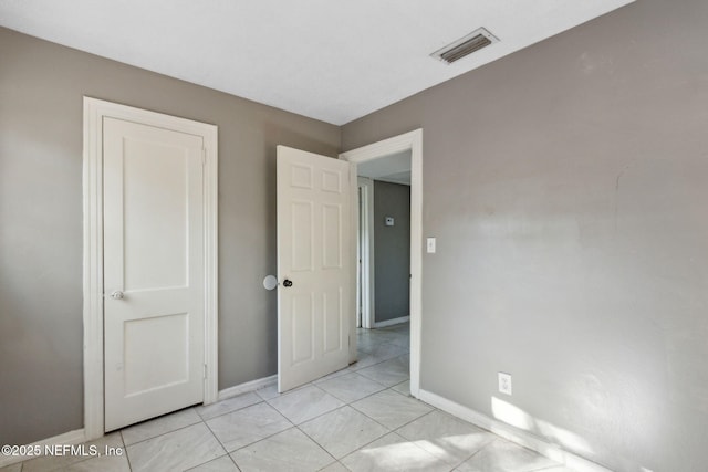 unfurnished bedroom with baseboards and visible vents