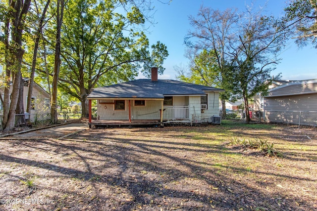 rear view of house featuring central air condition unit, fence, and a chimney