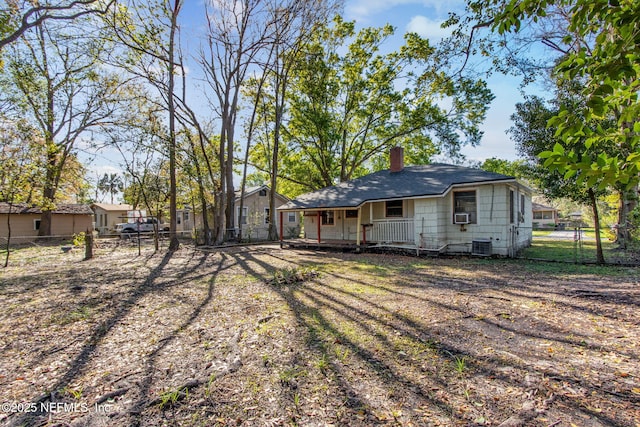 back of property featuring a gate, cooling unit, fence, central AC, and a chimney