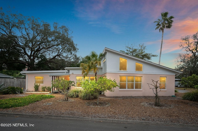 view of property exterior with stucco siding and fence