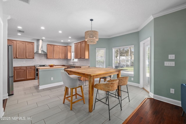 dining area featuring crown molding, visible vents, baseboards, and a textured ceiling