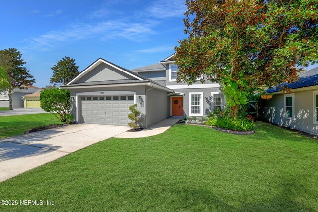 view of front of house featuring a garage, concrete driveway, a front lawn, and stucco siding