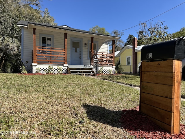 view of front of property featuring covered porch and a front yard