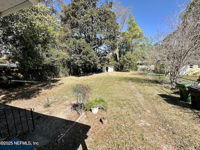 view of yard with an outbuilding, a storage shed, and fence