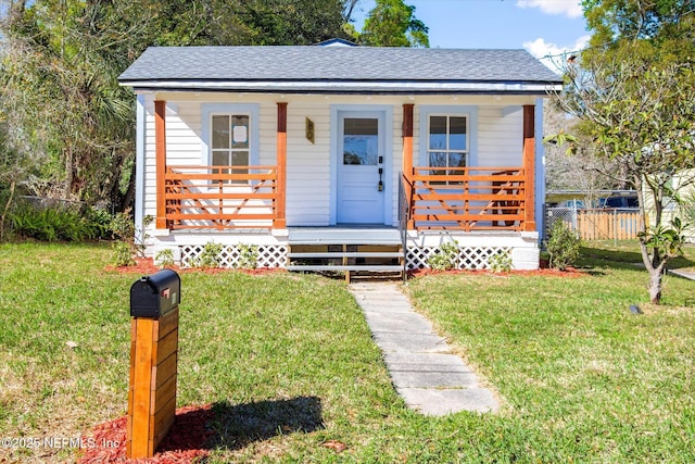 80 Anderson St, Saint Augustine, FL 32084 - bungalow featuring a porch, fence, a front yard, and roof with shingles