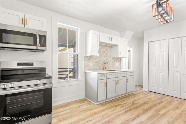 80 Anderson St, Saint Augustine, FL 32084 - kitchen with decorative backsplash, light wood-style floors, appliances with stainless steel finishes, and a sink