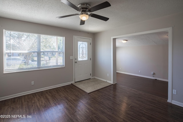 foyer entrance featuring ceiling fan, wood finished floors, baseboards, and a textured ceiling