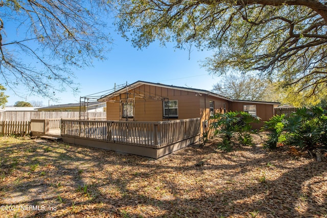 back of property with a deck and fence