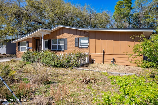 view of front facade featuring brick siding and board and batten siding