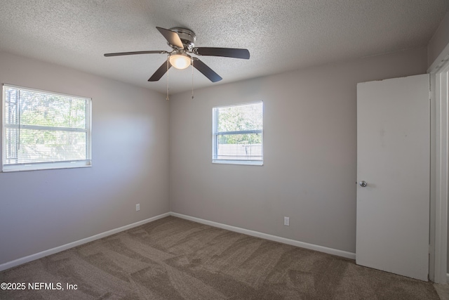 spare room featuring a textured ceiling, a ceiling fan, baseboards, and carpet floors