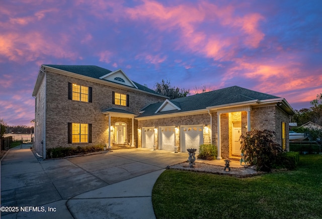 view of front of home featuring a garage, brick siding, concrete driveway, and a front lawn