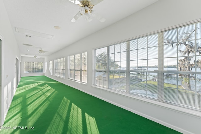 unfurnished sunroom featuring visible vents and a ceiling fan