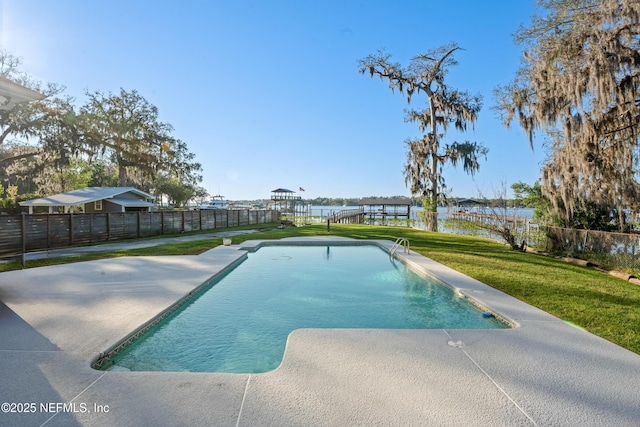 view of swimming pool with a water view, fence, a yard, a fenced in pool, and a patio area