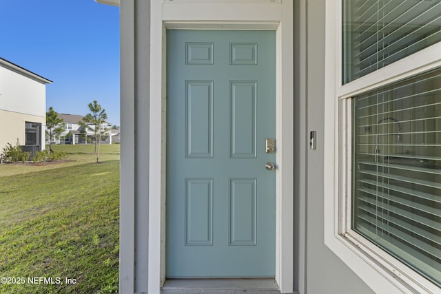 entrance to property with a lawn