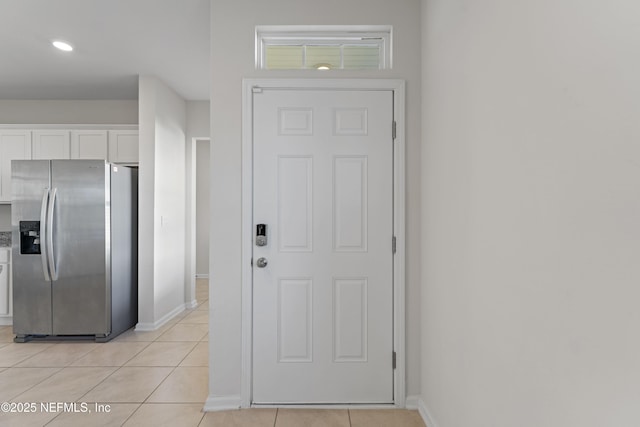 entryway with light tile patterned floors and baseboards