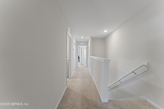 corridor with an upstairs landing, recessed lighting, light carpet, and baseboards