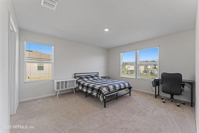 carpeted bedroom featuring visible vents, baseboards, and a textured ceiling