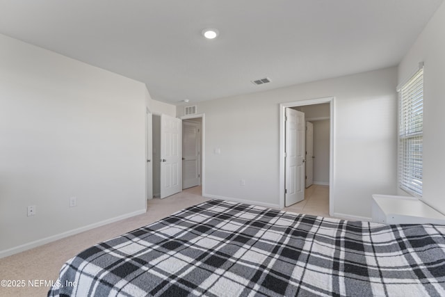 bedroom with light colored carpet, visible vents, and baseboards