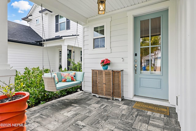 property entrance featuring a shingled roof