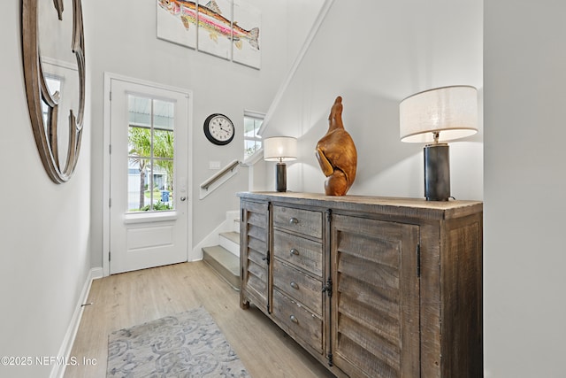 entryway with baseboards and light wood-style flooring