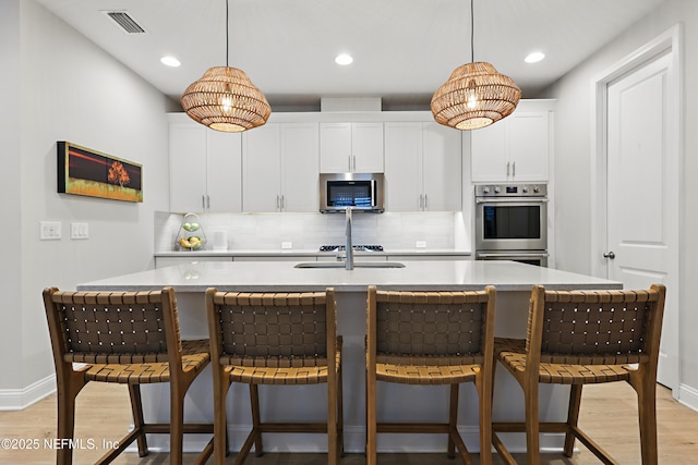 kitchen with visible vents, light wood finished floors, appliances with stainless steel finishes, and light countertops